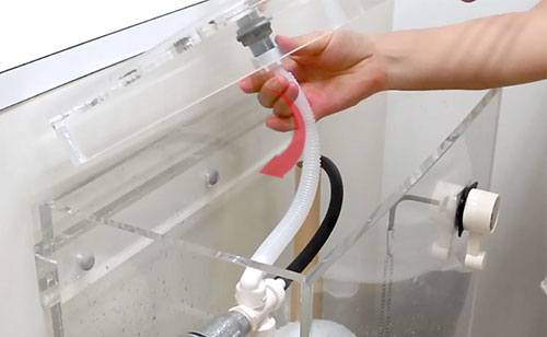 元々ついているボールタップの補助水管や連結ホースを外す様子