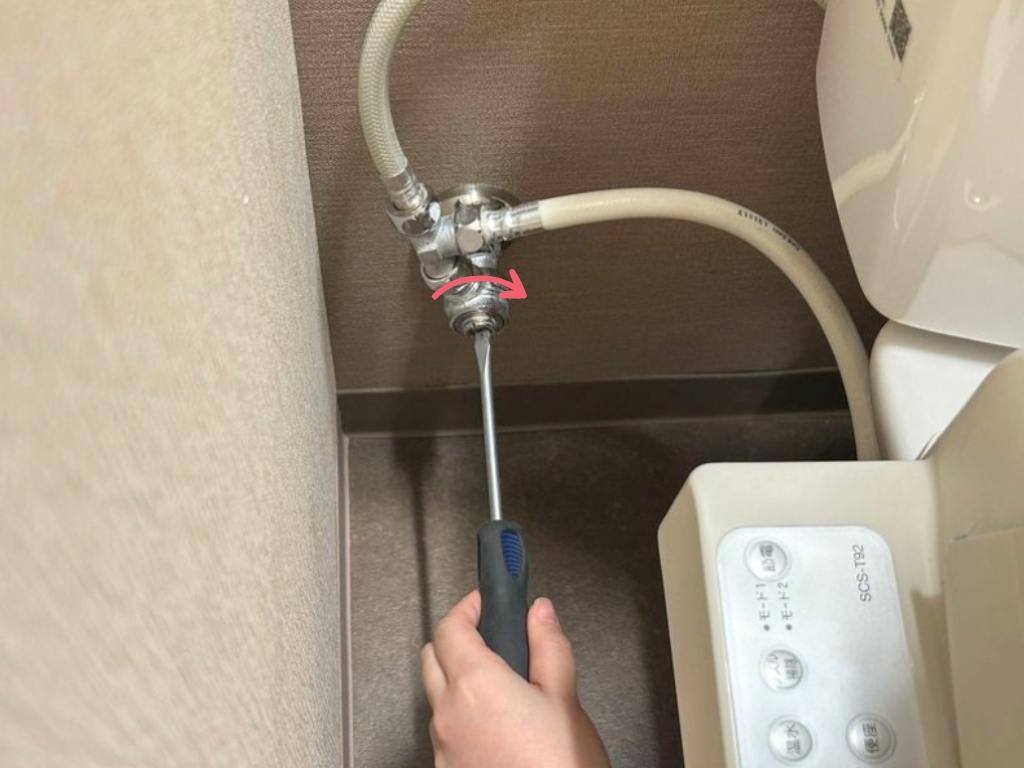 トイレの止水栓をドライバーで締めている様子