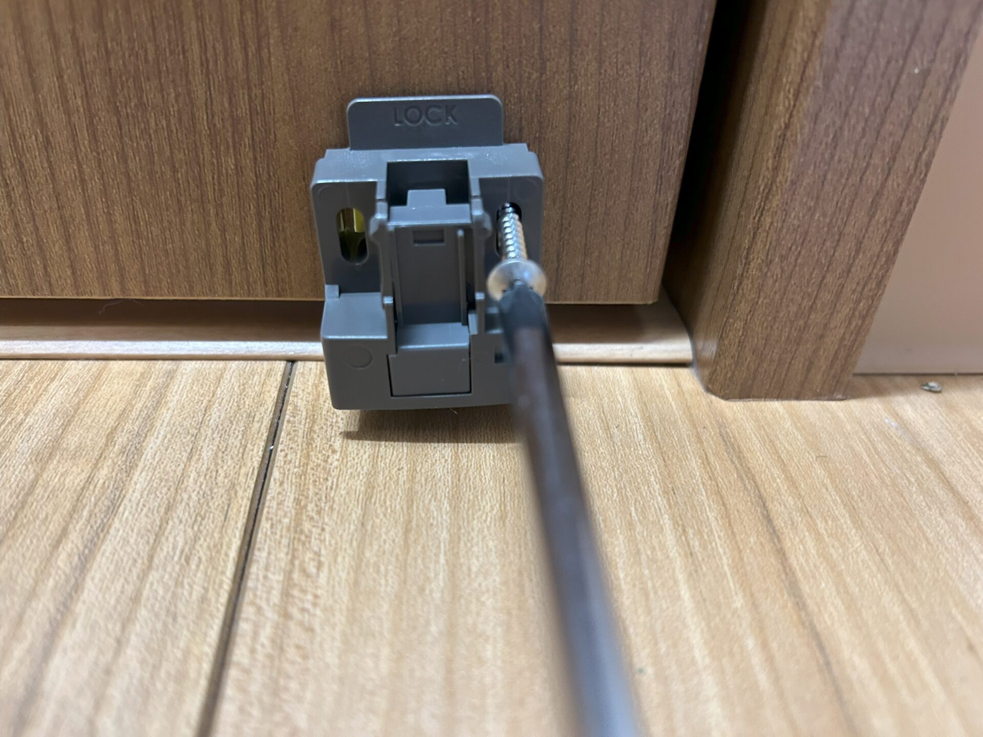 本体を付属のねじで扉に取り付ける様子