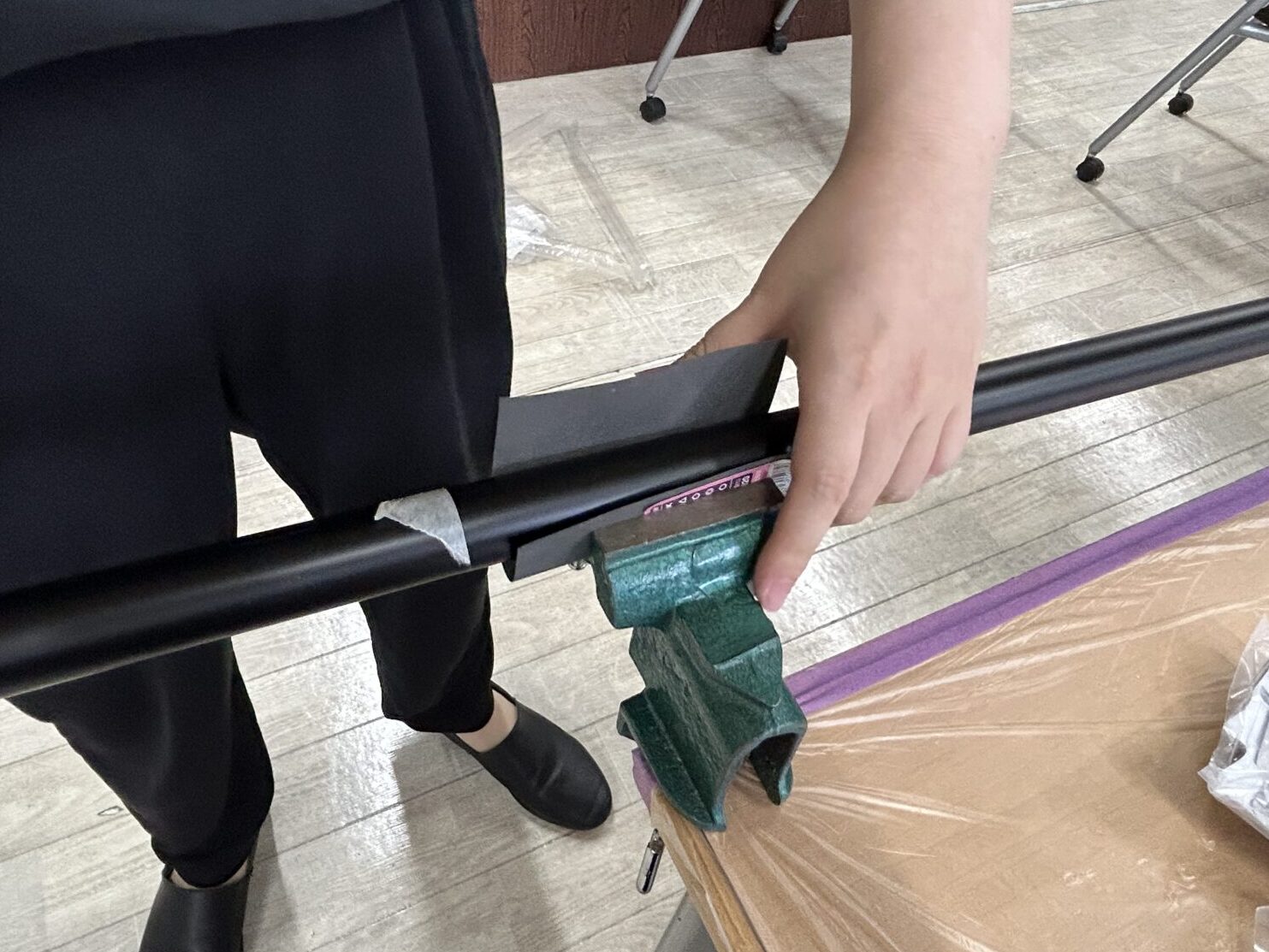 バイスで滑り止めシートとパイプを挟む様子