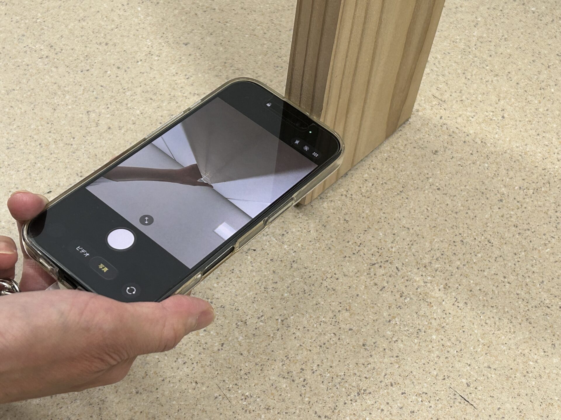 木材にスマホを当てて、内カメで曲がっていないか確認する画像